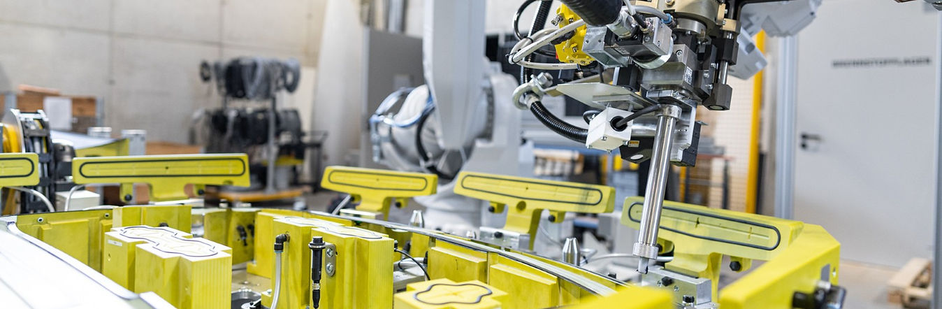 6-Achs-Roboter trägt Klebstoff präzise auf ein CFK-Bauteil in einer automatisierten Klebezelle auf.