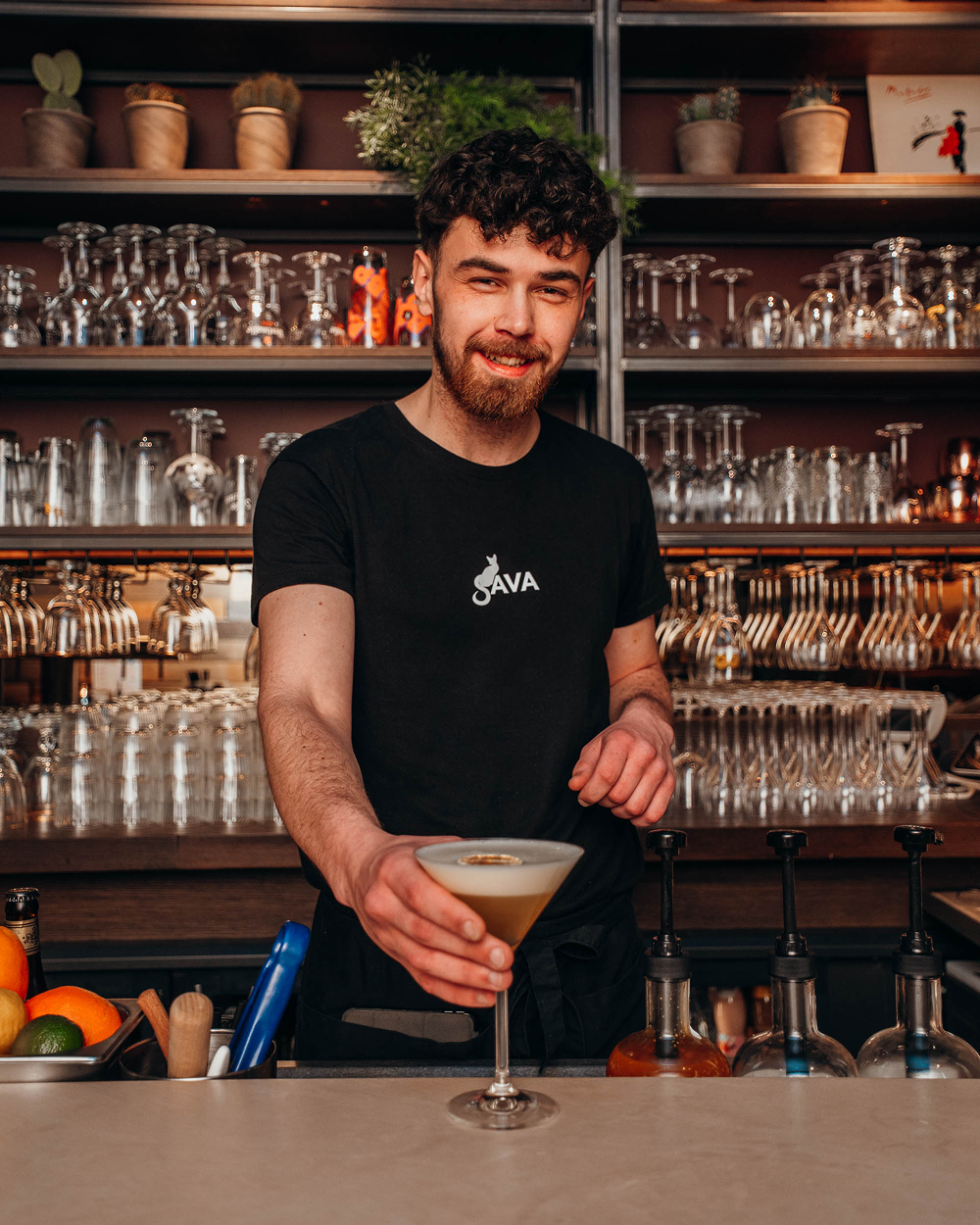 Barman van Sava serveert een verse cocktail aan de bar in Mechelen