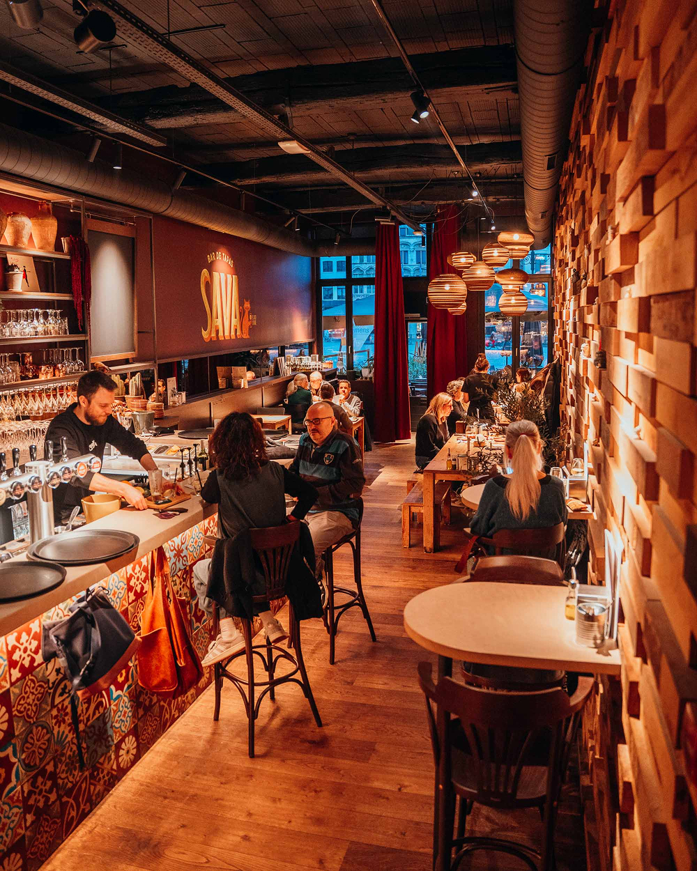 Warm interieur van tapasbar Sava met lange bar en gezellige eetruimte in Mechelen