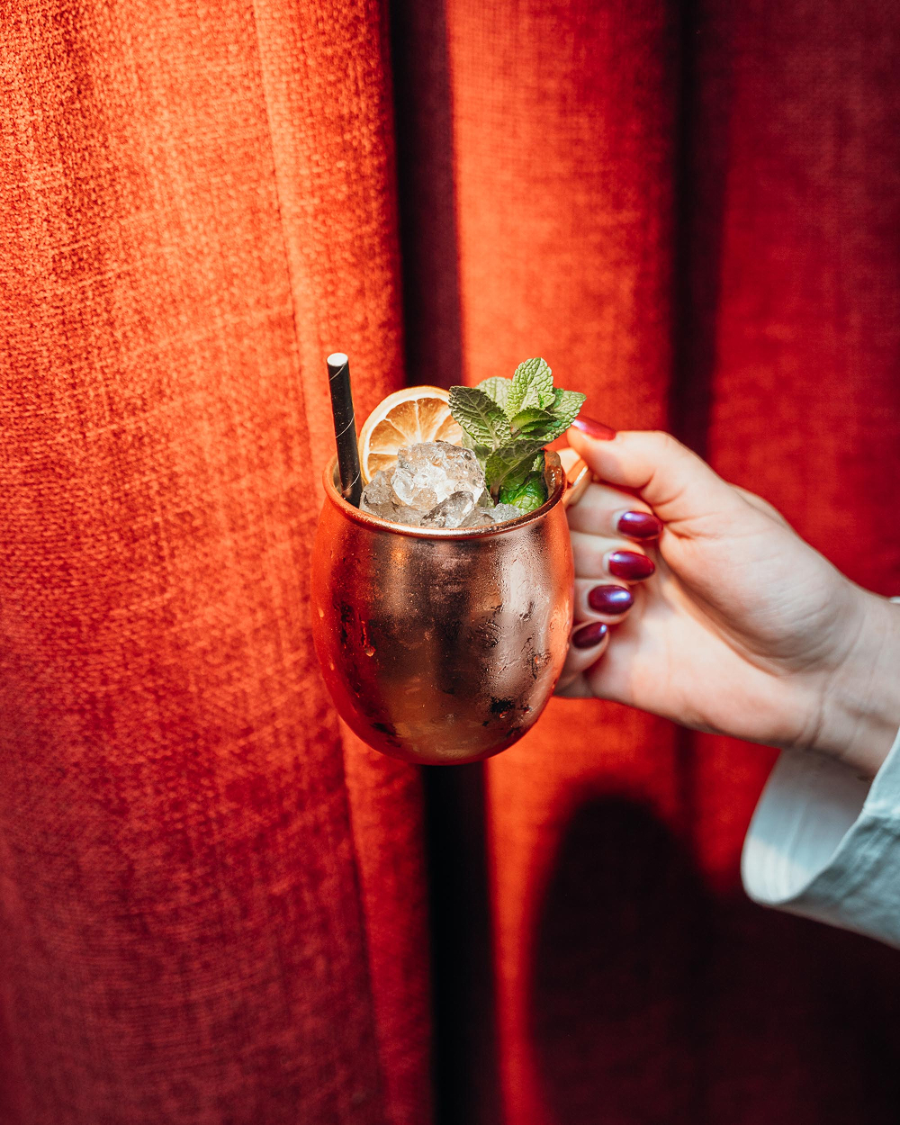 Cocktail in koperen mok met verse munt en gedroogde sinaasappel bij Sava in Mechelen