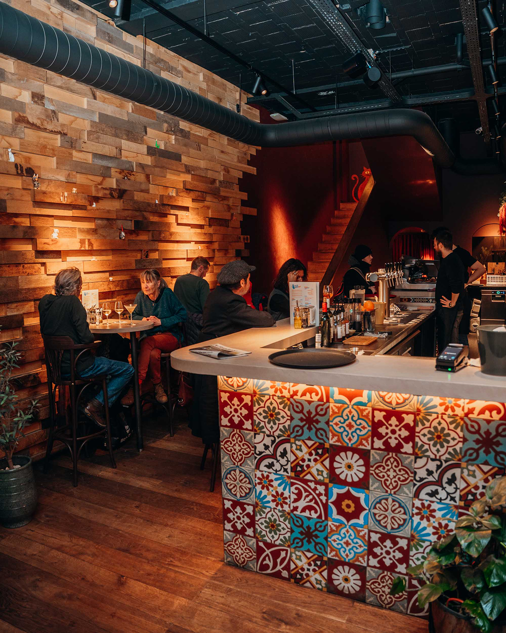 Sfeervol interieur van Sava met gasten aan de bar met kleurrijke Spaanse tegels