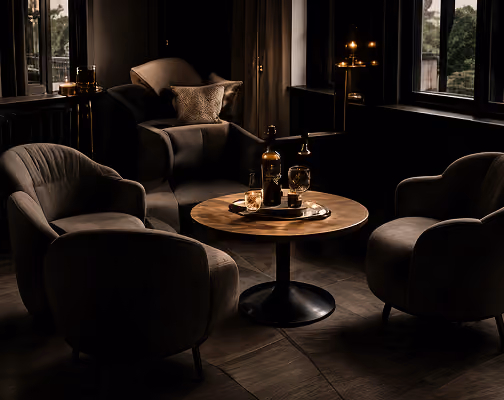 Intimate lounge seating around a round cocktail table with candlelight and a curated drink tray