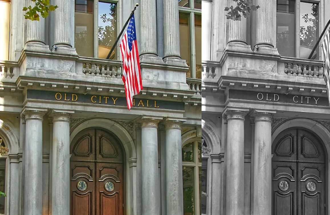 Entrance of Old City Hall with large columns, wooden double doors, and an American flag.