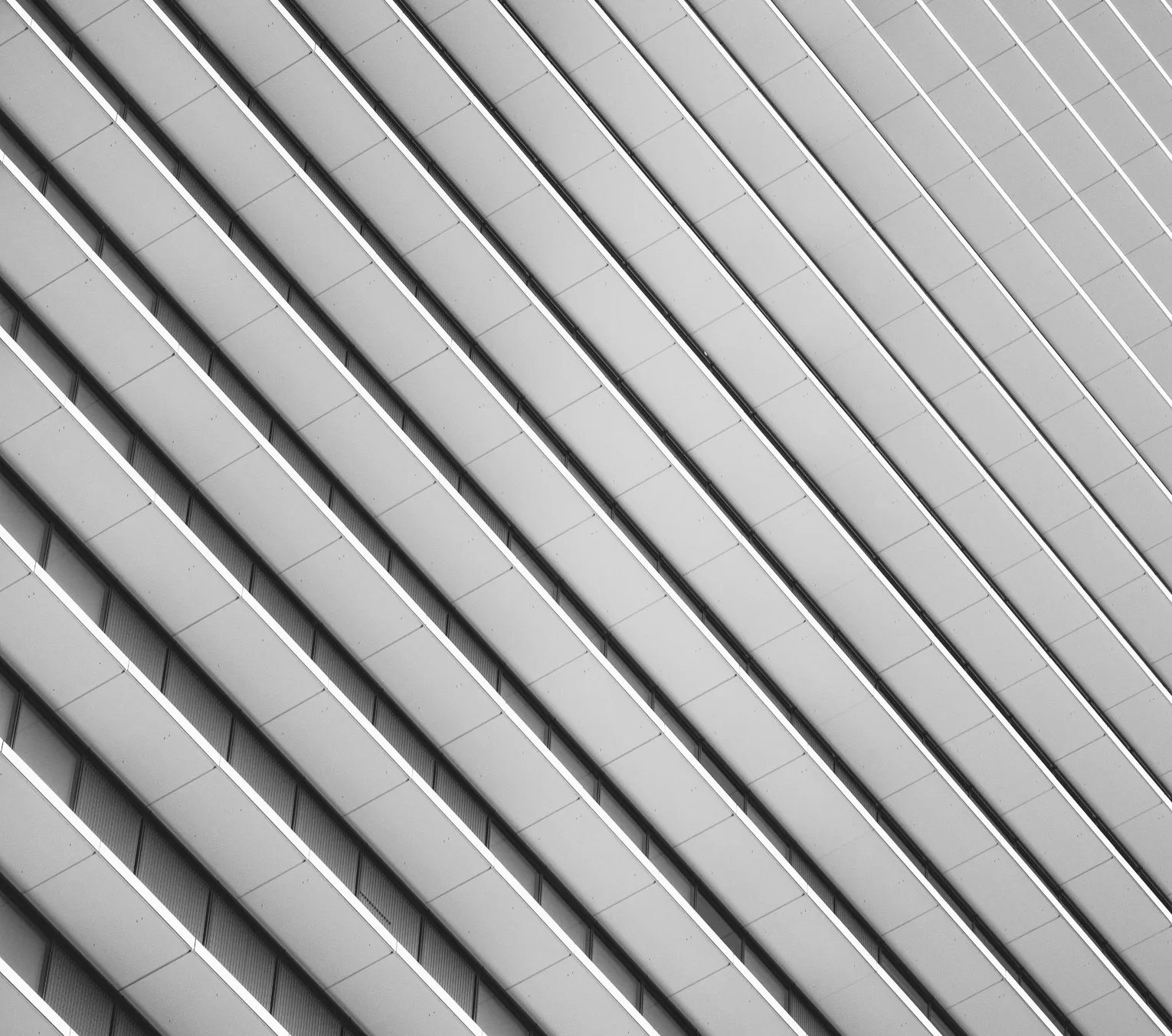 Abstract black and white photo of a building's repetitive angled balconies.