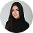 Portrait of a young woman with long dark hair wearing a black turtleneck smiling