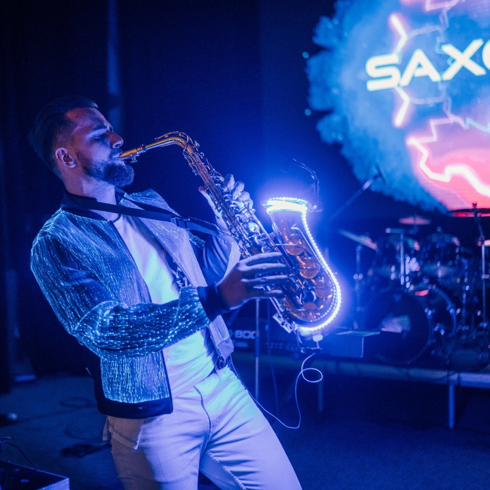 Saxofonista hraje živě do DJ setu během welcome části