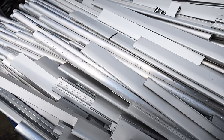 Stack of shiny aluminum metal tubes and bars in various shapes and sizes.