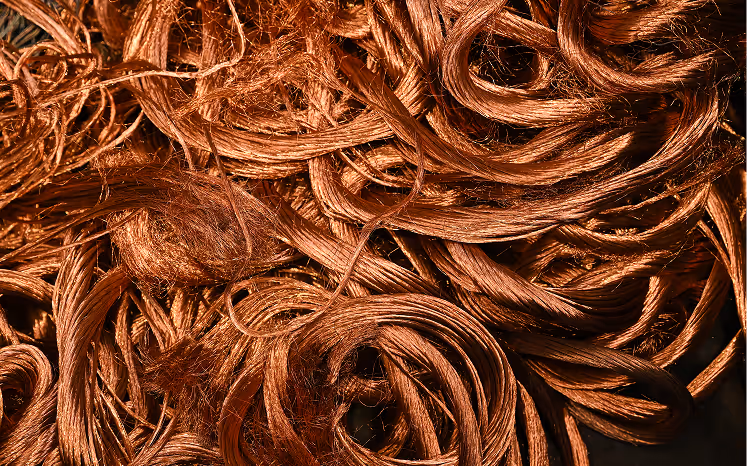 Close-up of tangled copper wire strands with shiny reddish-brown metallic texture.
