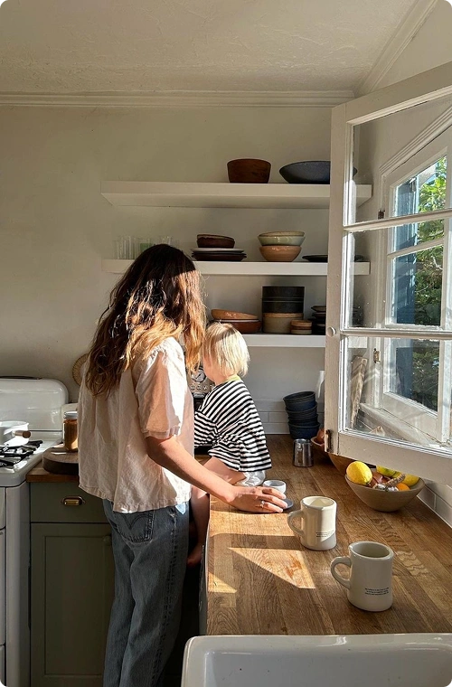 A woman is cooking with her child in the kitchen