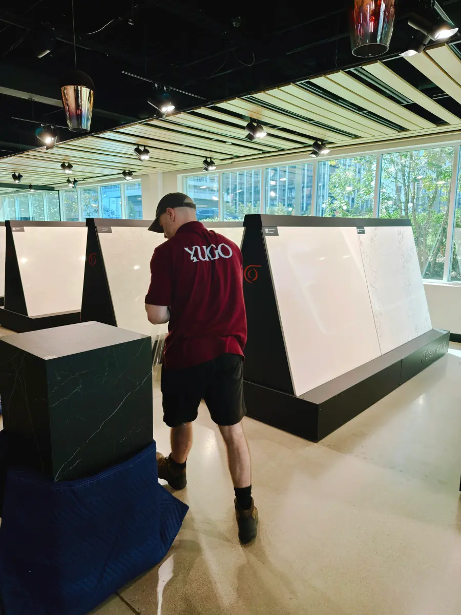 A Yugo crew member moving display panels in a showroom