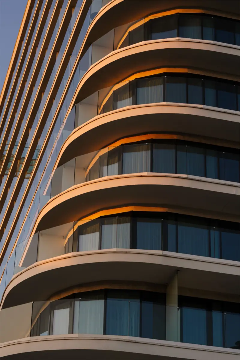 A curved condominium tower with rounded balconies against the sky