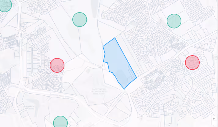 Map showing a large blue outlined area with nearby green and red circular markers over residential streets.