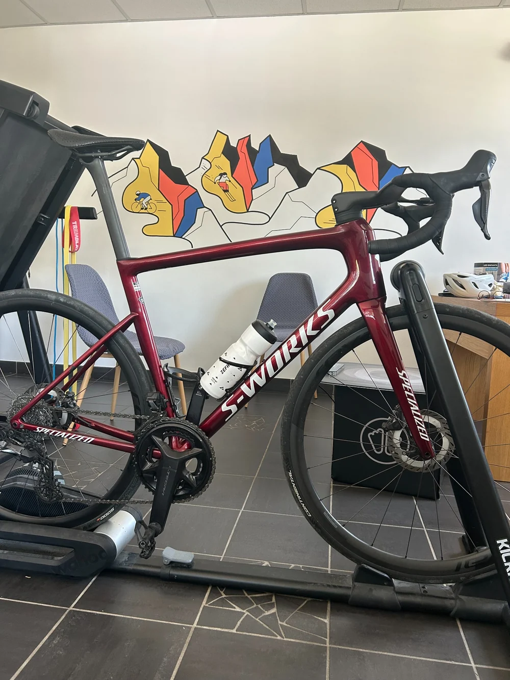 Vélo Specialized S-Works rouge sur home trainer pour une étude posturale vélo à Saint-Martin-d’Hères.