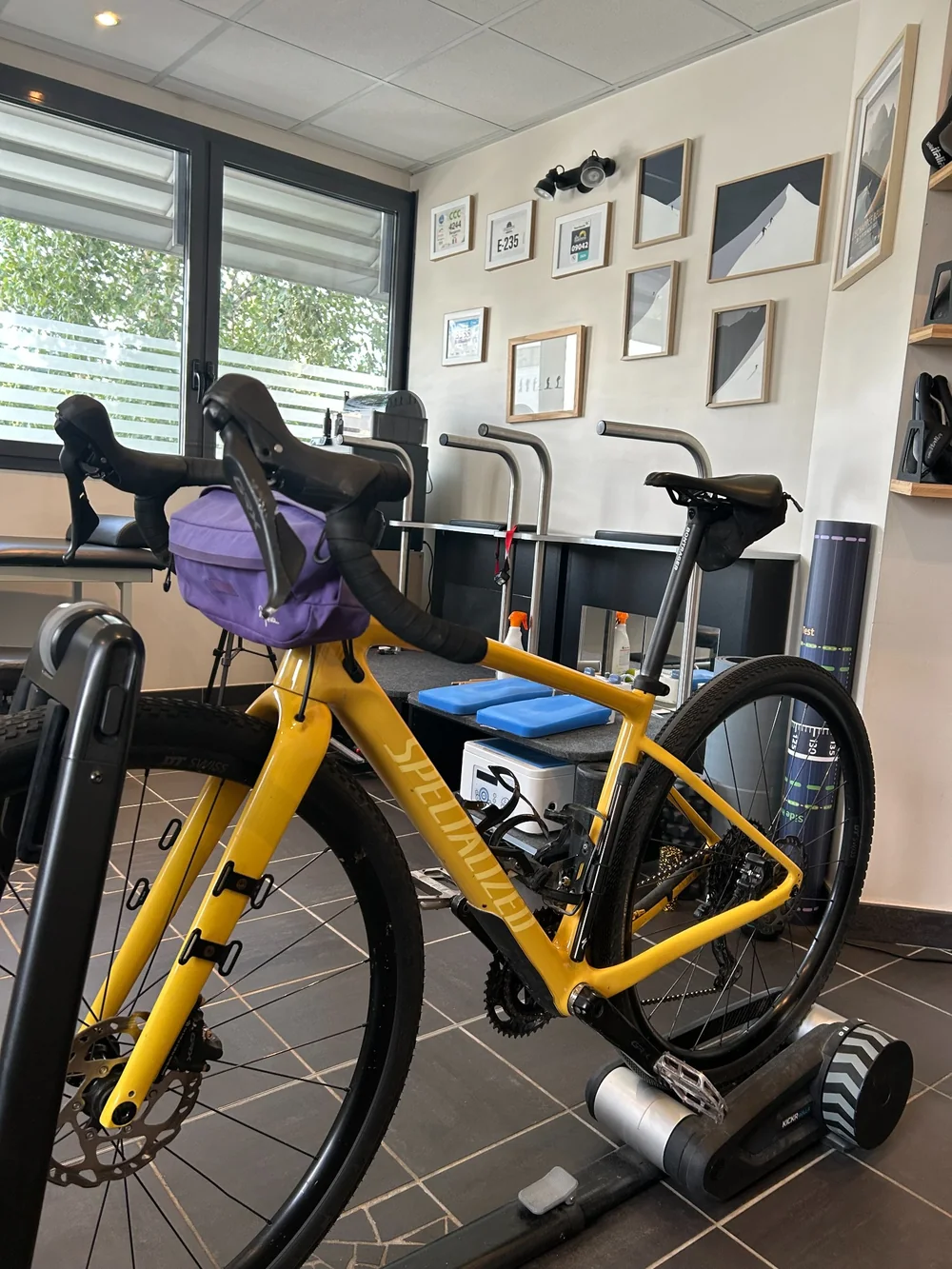 Vélo Specialized jaune avec sacoche de guidon sur home trainer chez Belledonne Podologie, près de Grenoble.