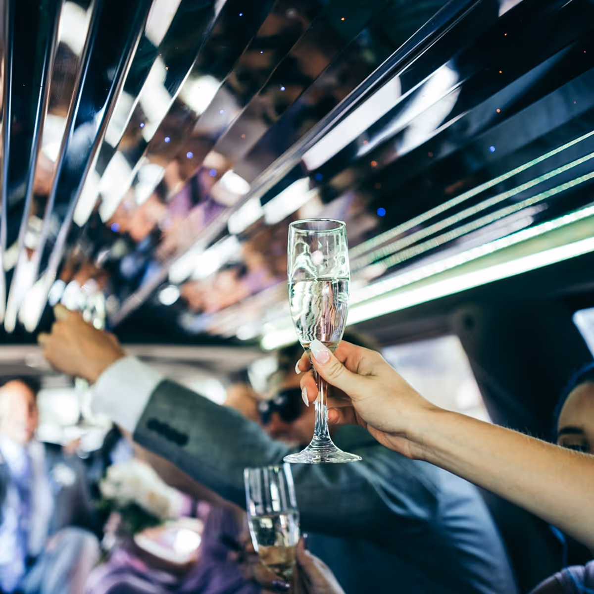 People inside a limousine raising champagne glasses in a celebratory toast.