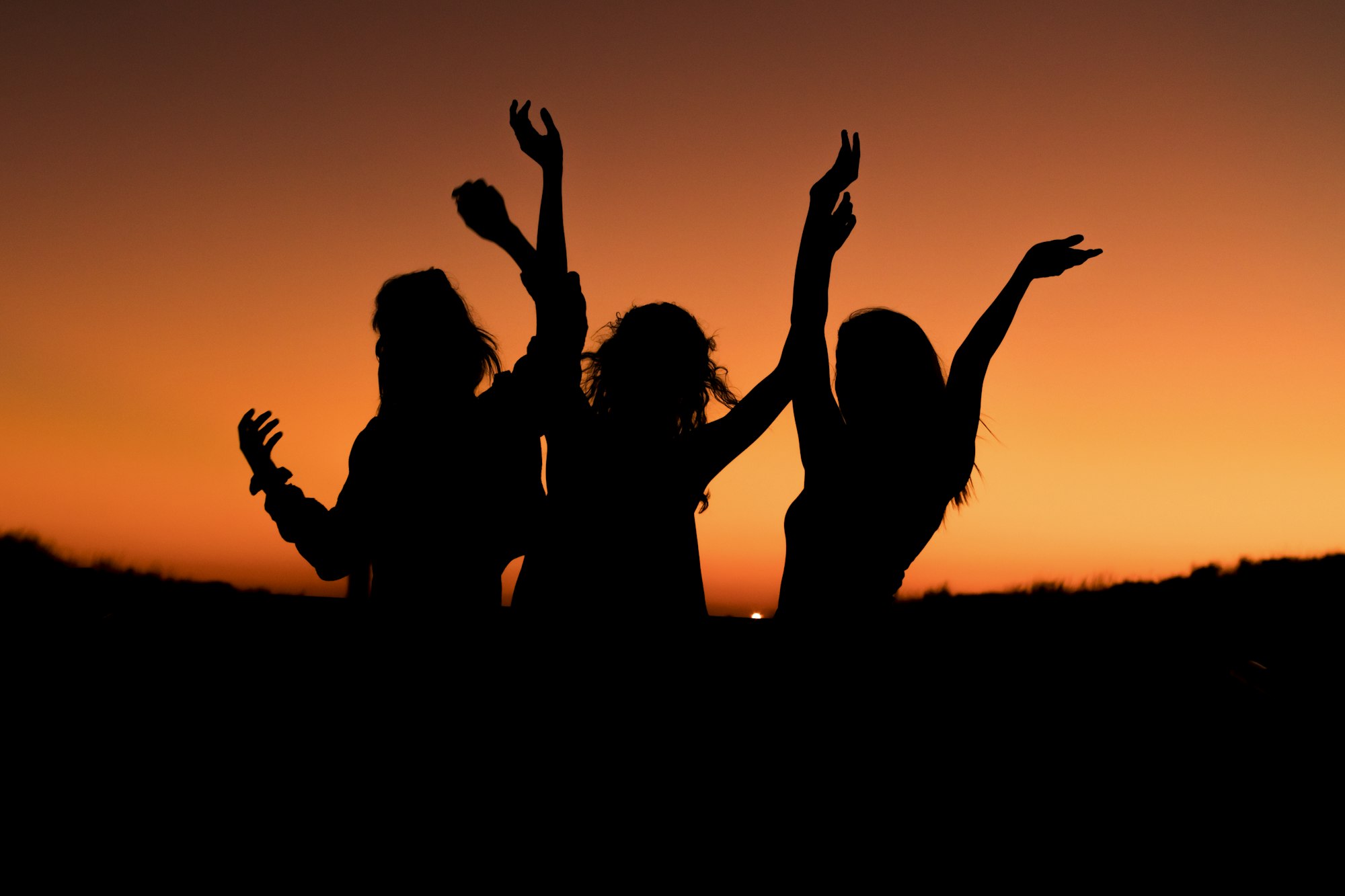 Women celebrating bachelorette party at night, dancing and having fun.