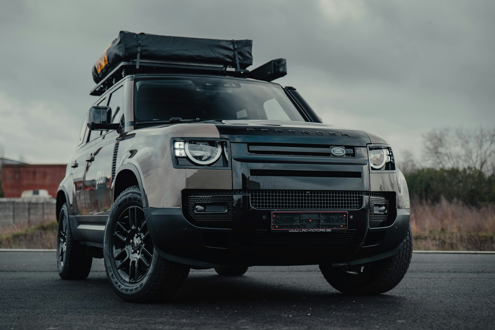 Black full-size luxury SUV on the road, similar to a Chevrolet Suburban.