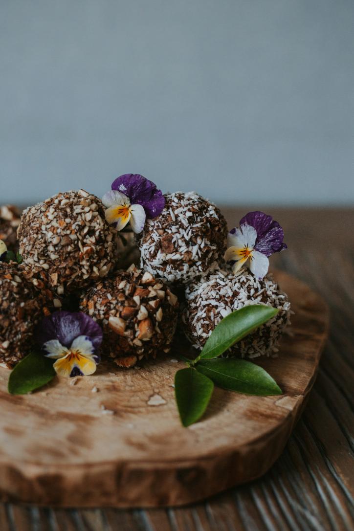 Date and cacao protein balls on a board, some cut in half