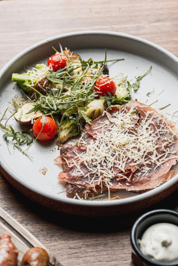 Sliced steak on rocket with parmesan shavings and tomatoes