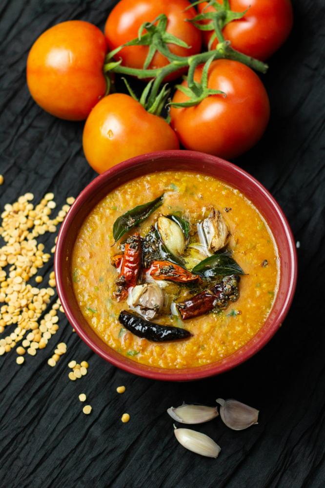 Bowl of golden red lentil dal with spinach and rice