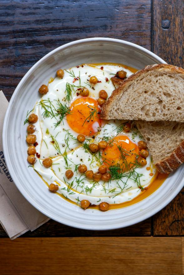 Two poached eggs on garlic yogurt, drizzled with red chilli butter and dill