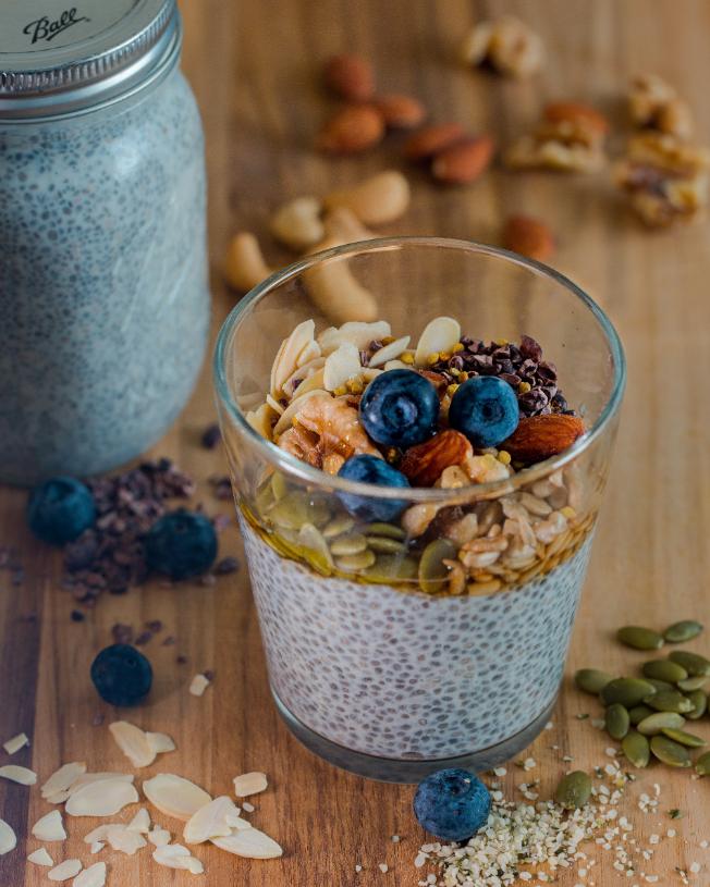 Chia seed pudding in a glass topped with diced mango, lime zest and pumpkin seeds
