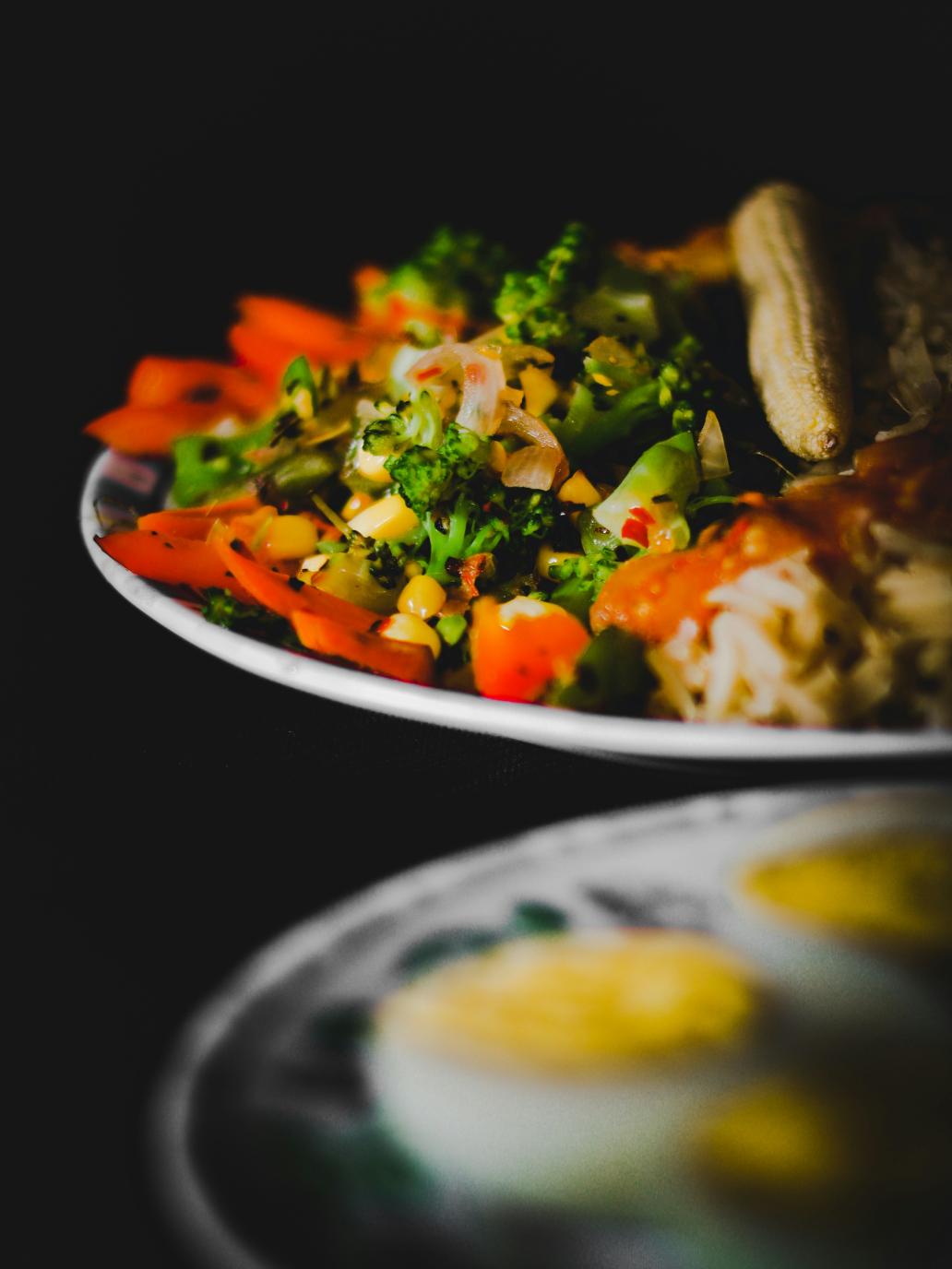 Smoked mackerel kedgeree with yellow spiced rice, halved soft-boiled eggs, spinach and lemon wedges in a pan