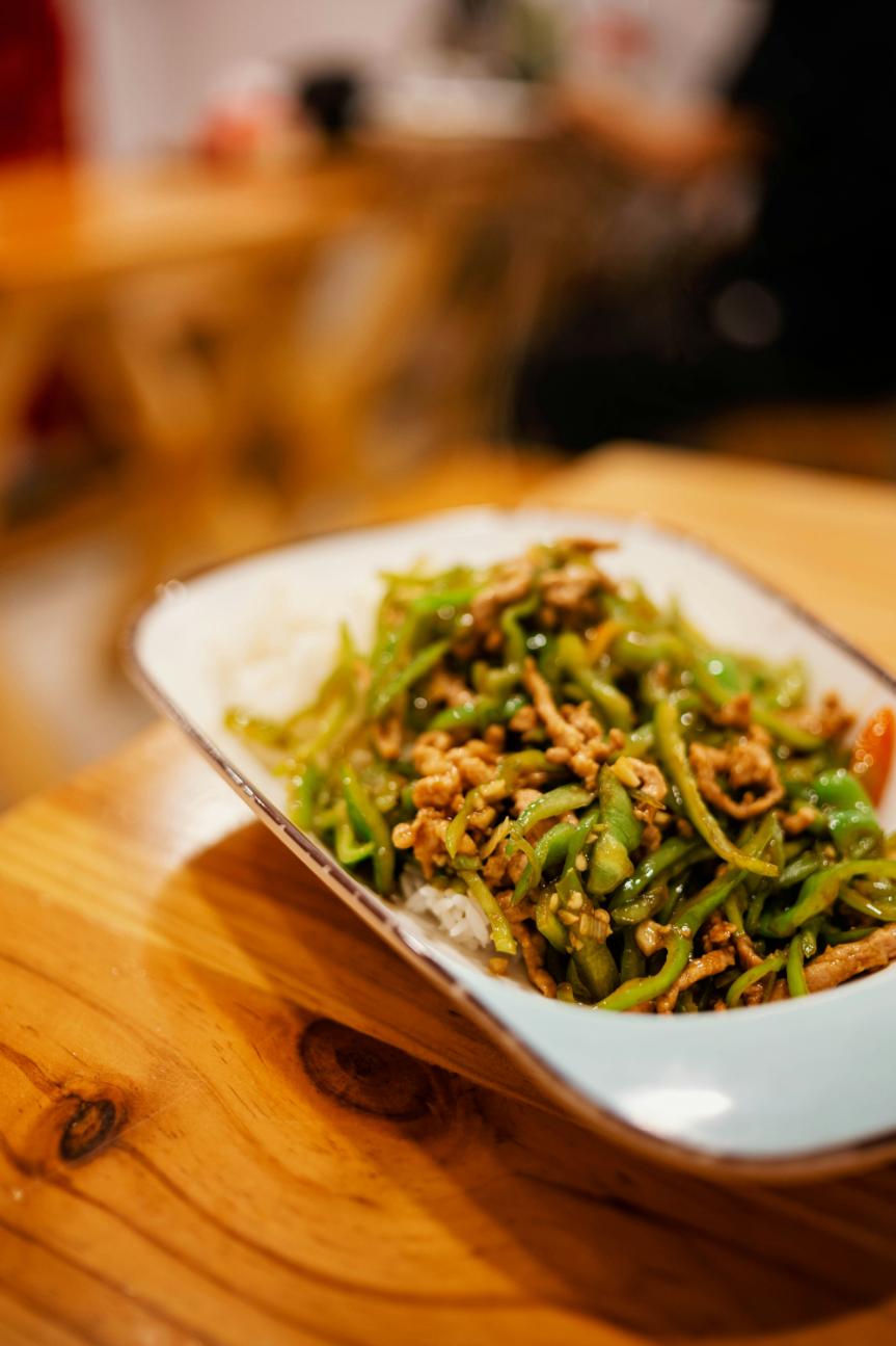 Bowl of chilli garlic edamame beans in their pods with sesame and lime