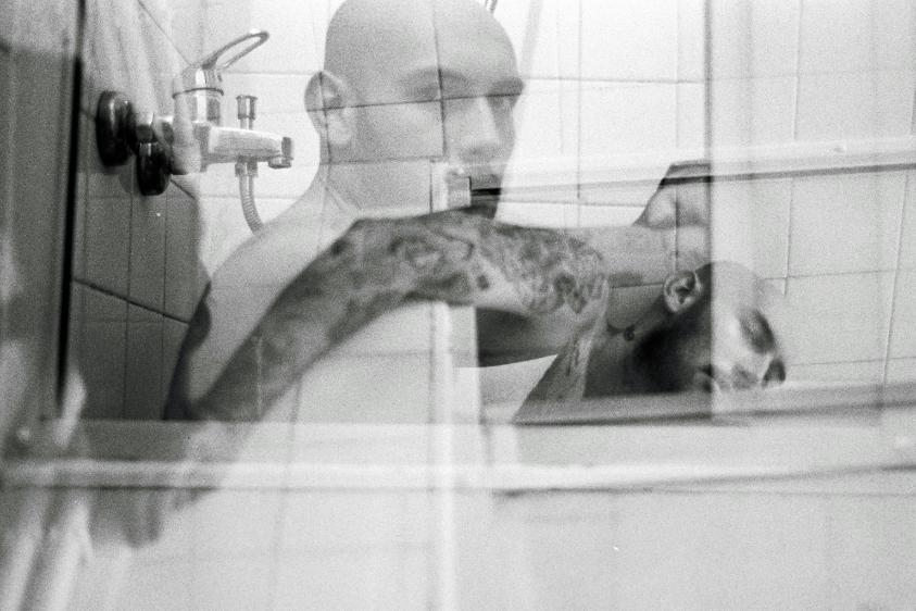 Worried man looking at himself in a bathroom mirror