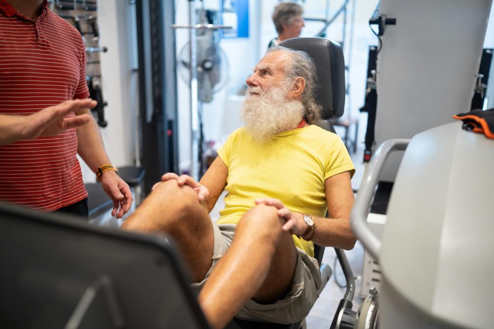 Man in his fifties lifting dumbbells in a gym