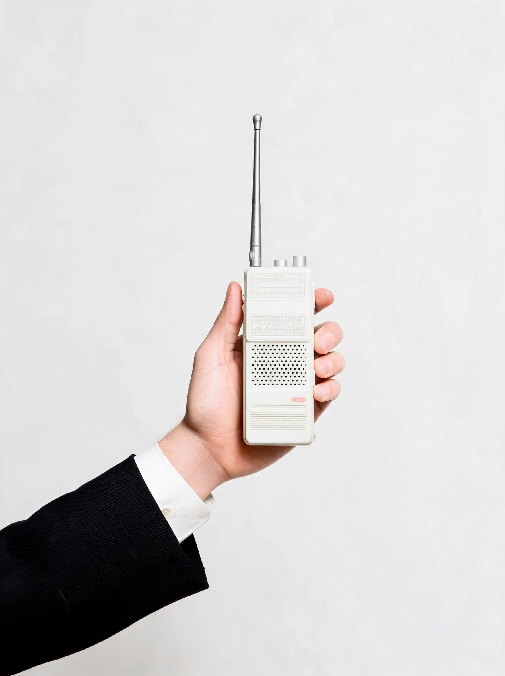 Hand holding a white retro portable radio