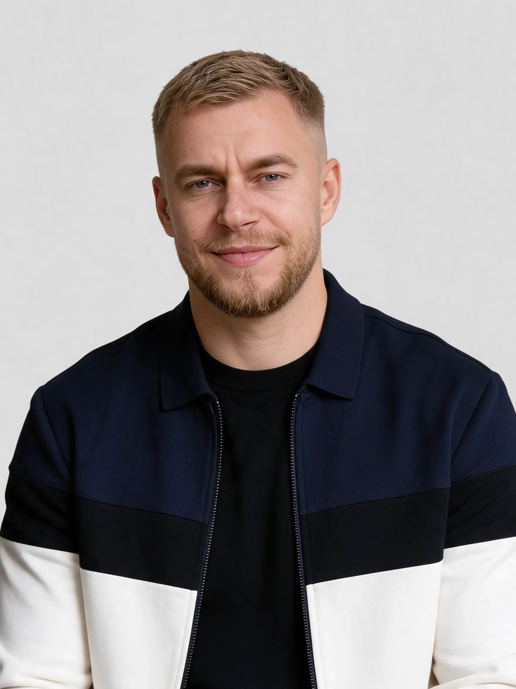Portrait of a bearded man in a dark color-block jacket