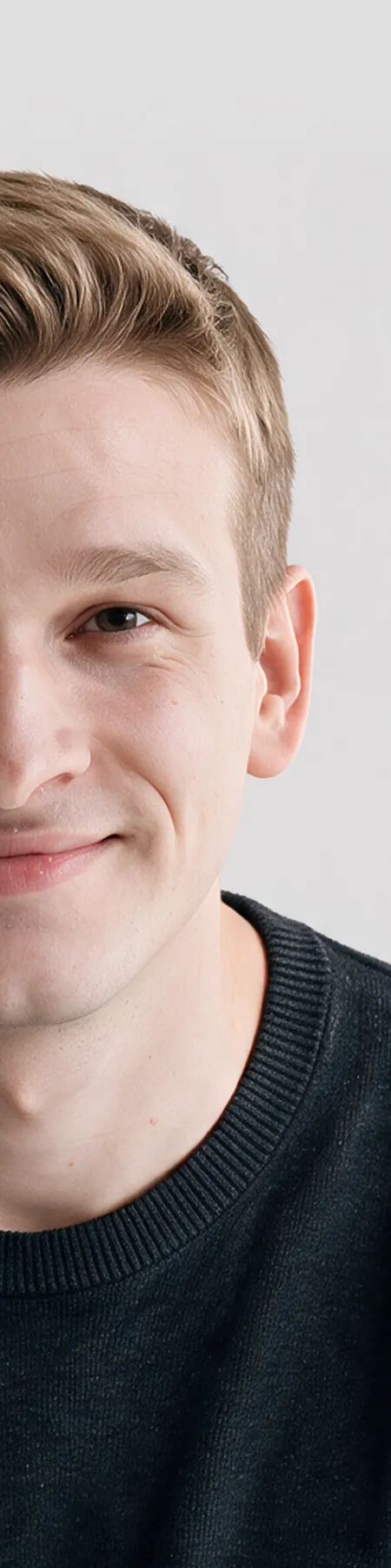 Close-up portrait of a smiling man with short blond hair