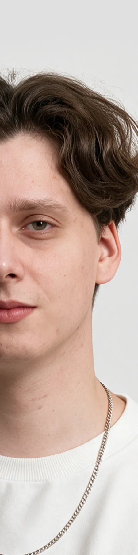 Close-up portrait of a young man with wavy brown hair