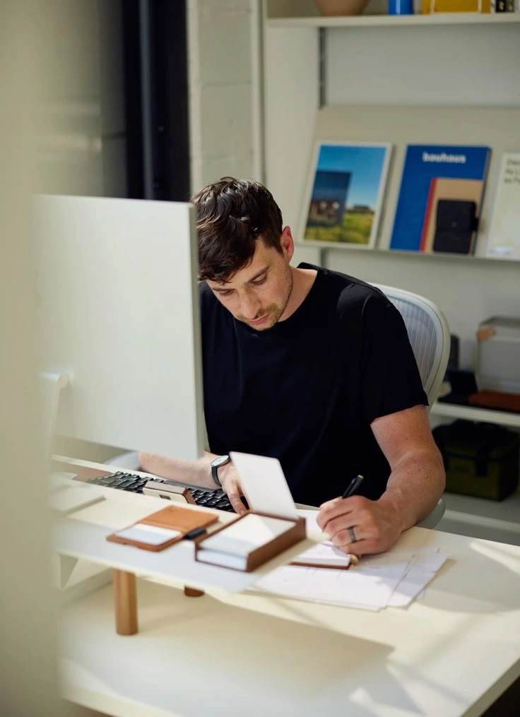 Designer sketching at a desktop workspace