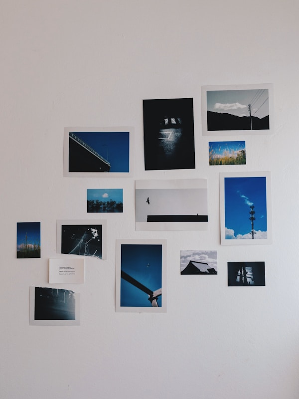 Collection of framed photographs displayed on a white wall.