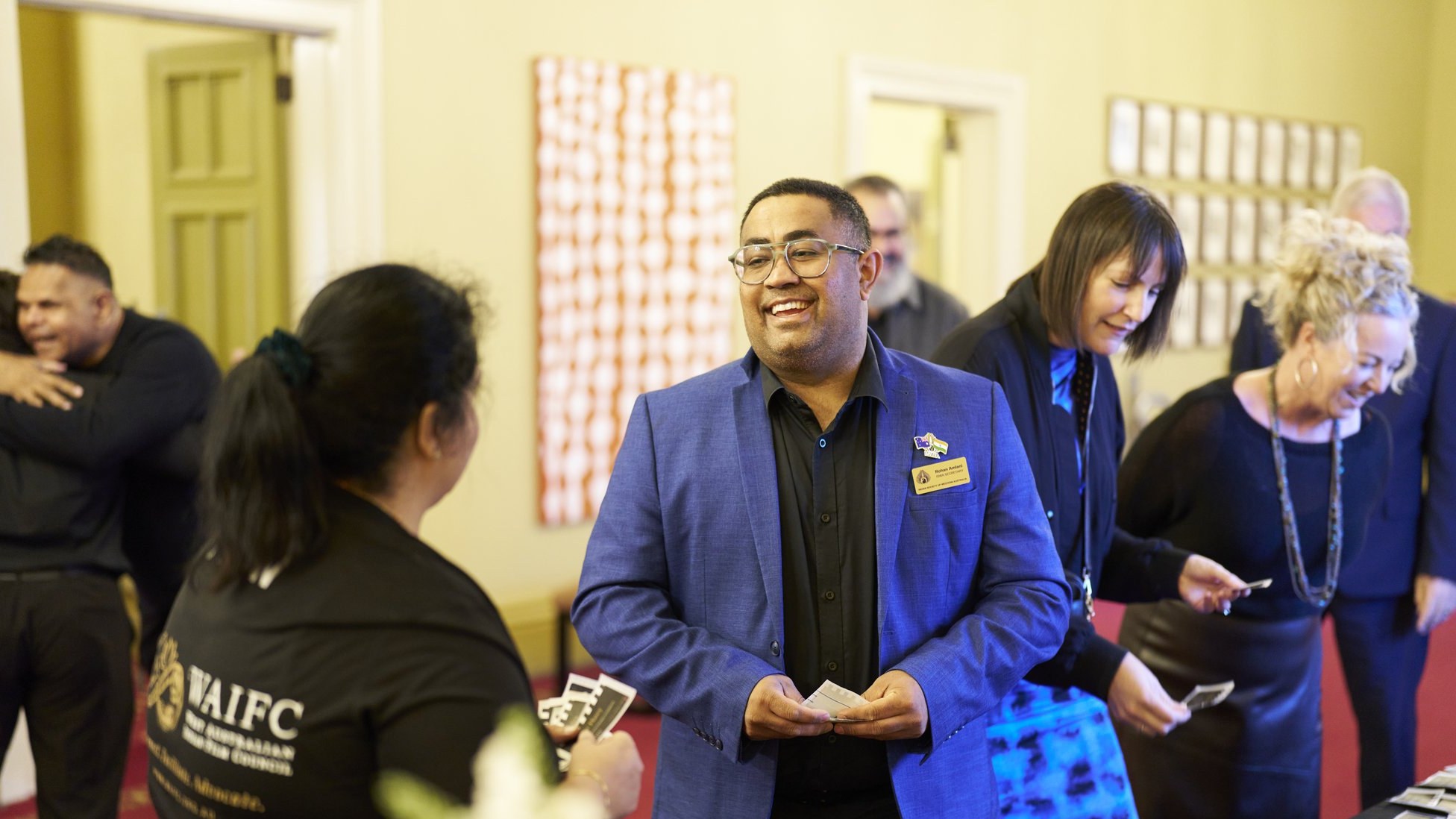 Guests arriving and collecting name badges at the WAIFC launch welcome desk