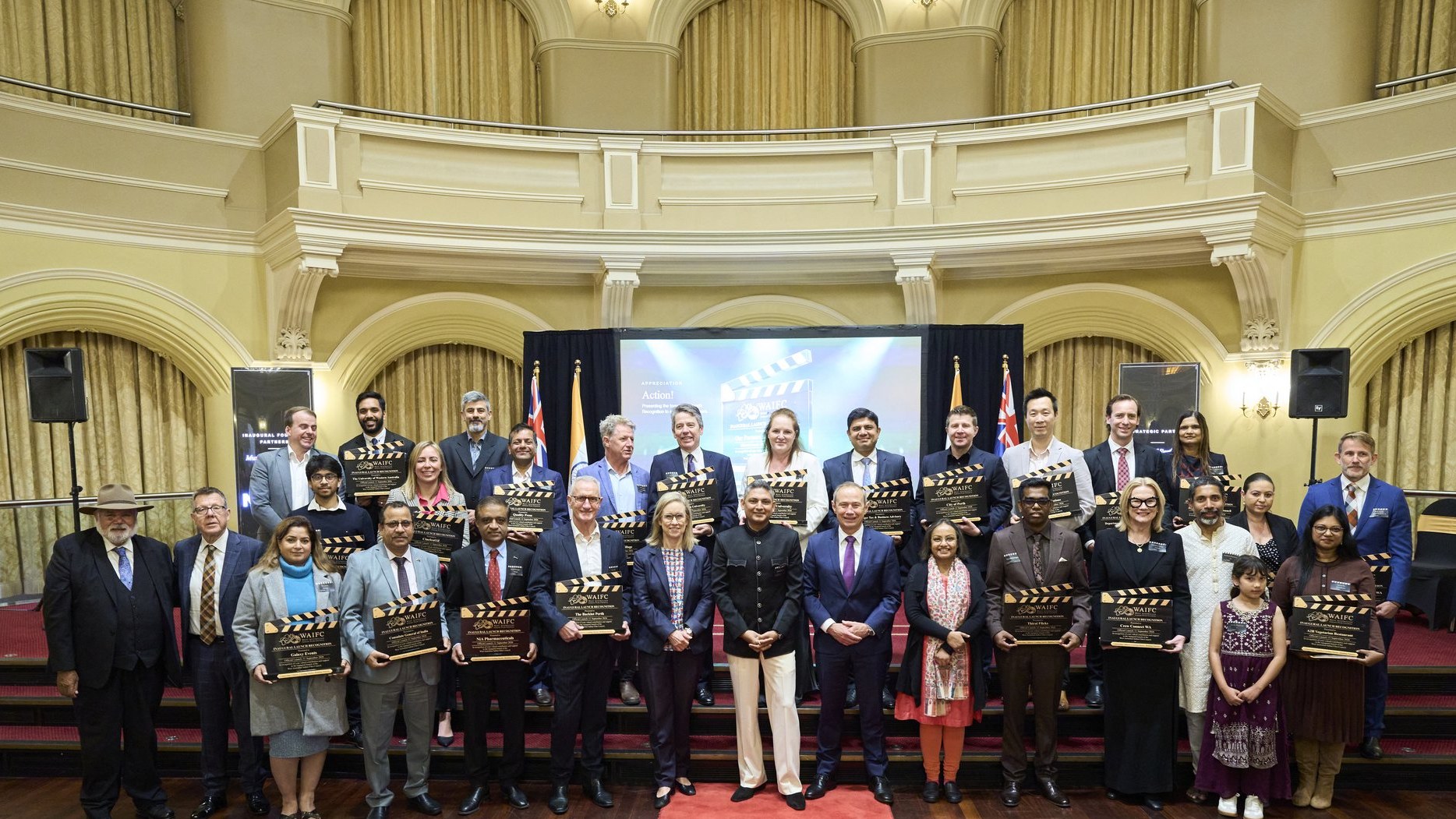 WAIFC founding, strategic and supporting partners on stage holding their clapperboards at Government House Ballroom