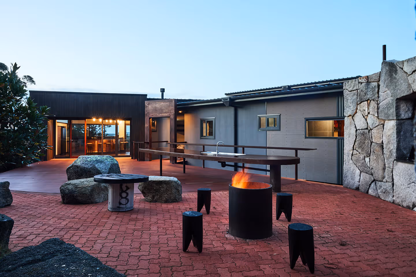 Wide angle shot of the outdoor area showing firepit, bbq and seating
