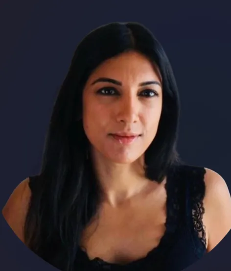 Woman with long black hair wearing a black lace top against a dark blue background.