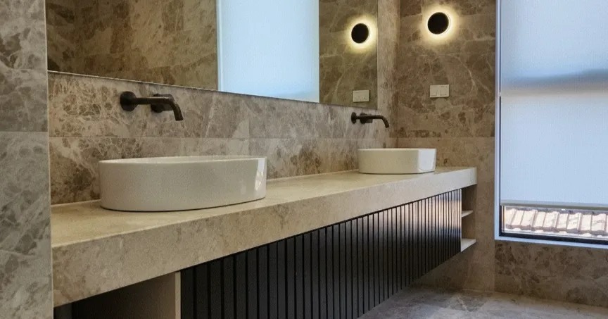 Double stone vanity with wall-mounted fittings and feature lighting