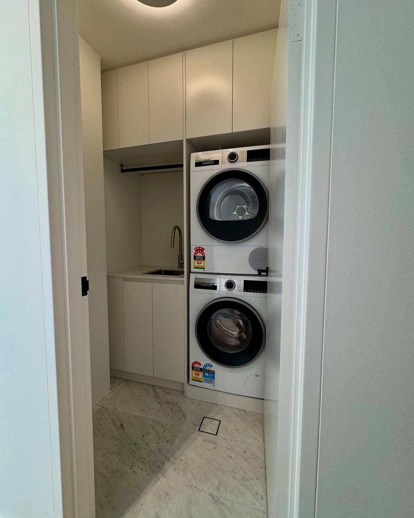 A compact laundry concealed behind full-height cabinetry.