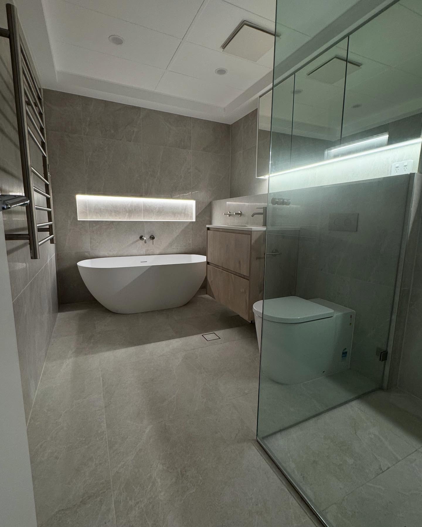 Main bathroom with a freestanding bath and glass shower.