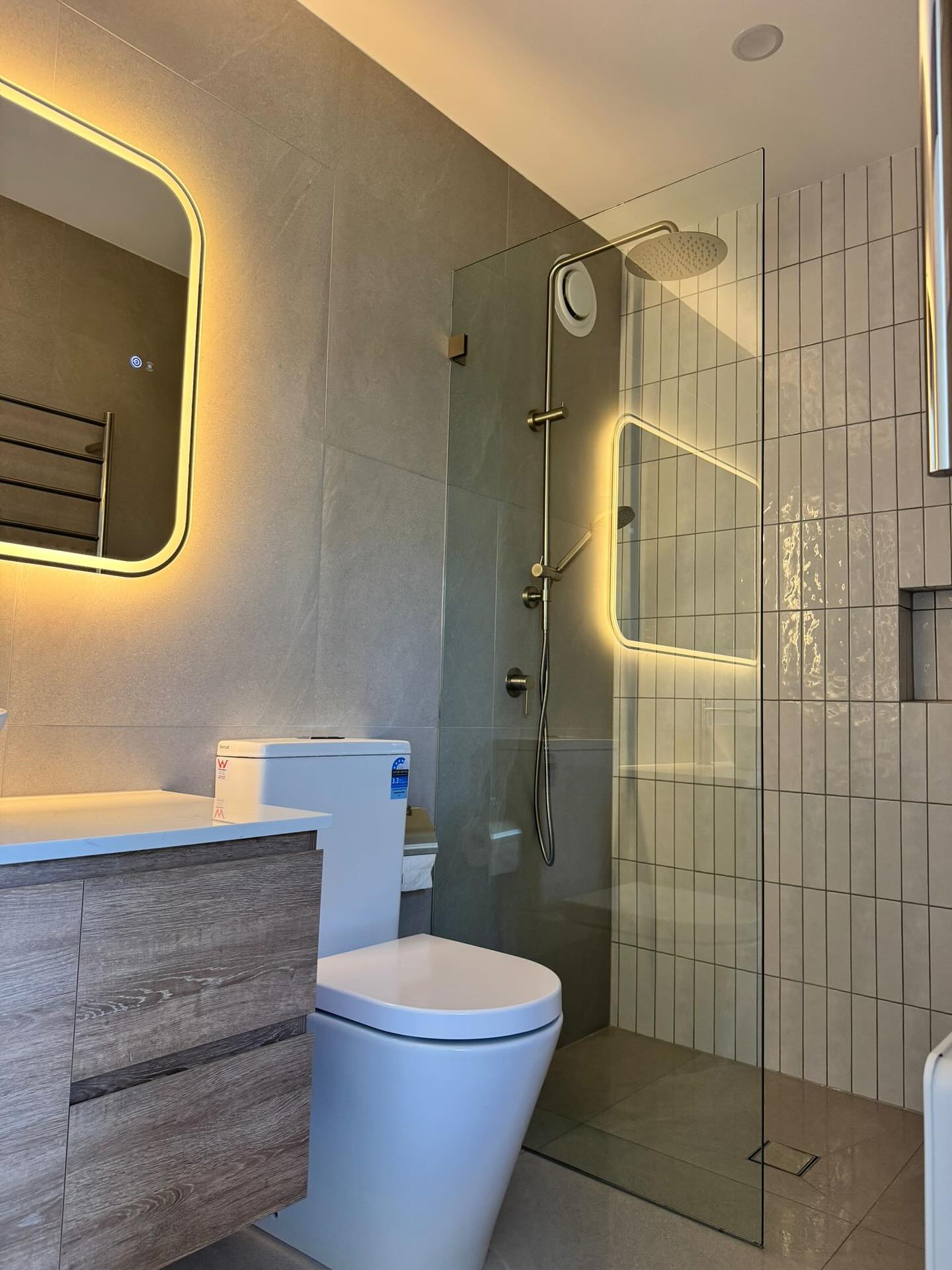 Frameless shower and custom vanity in the completed bathroom.
