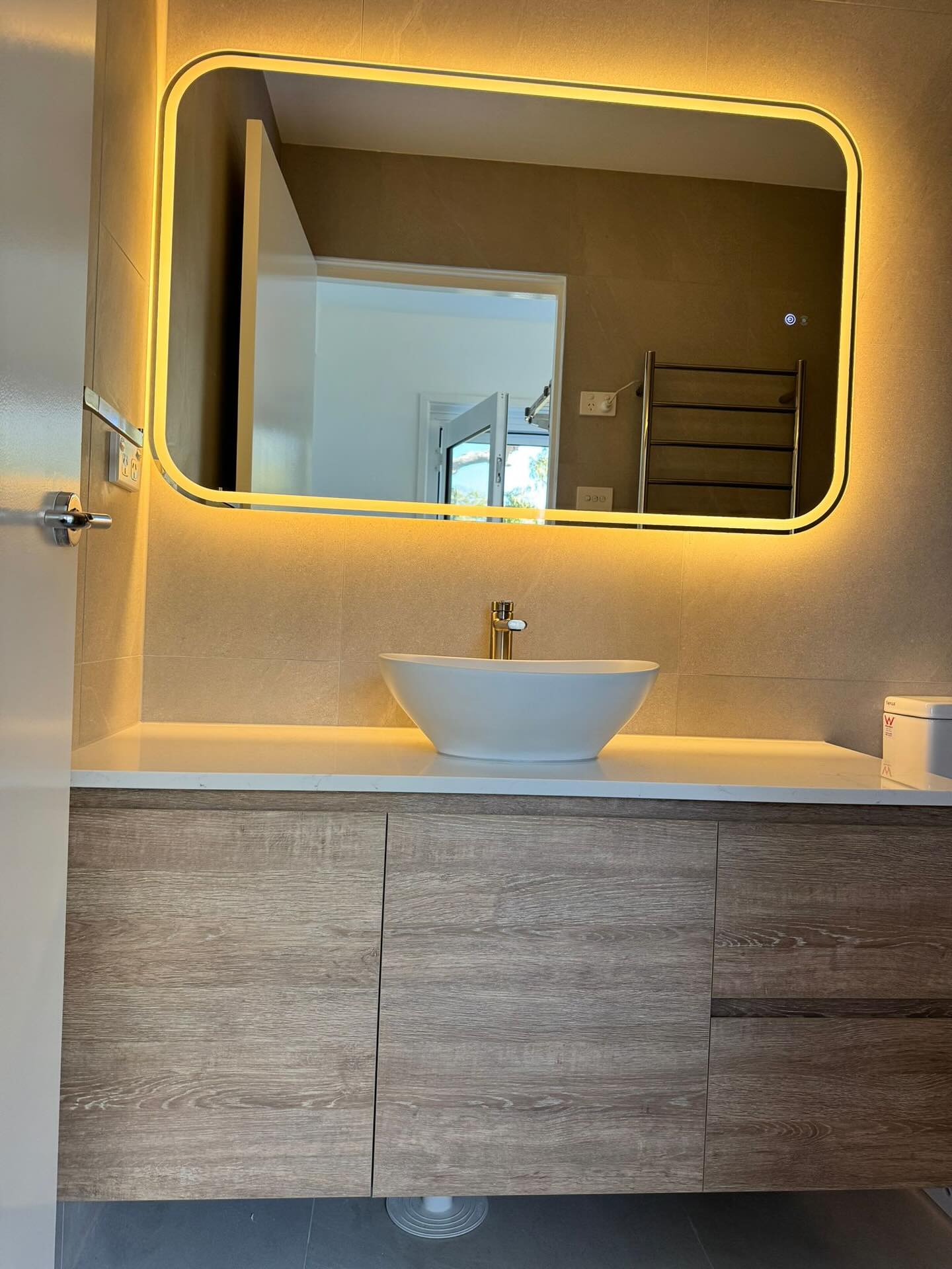 Vessel basin and softly illuminated mirror detail.