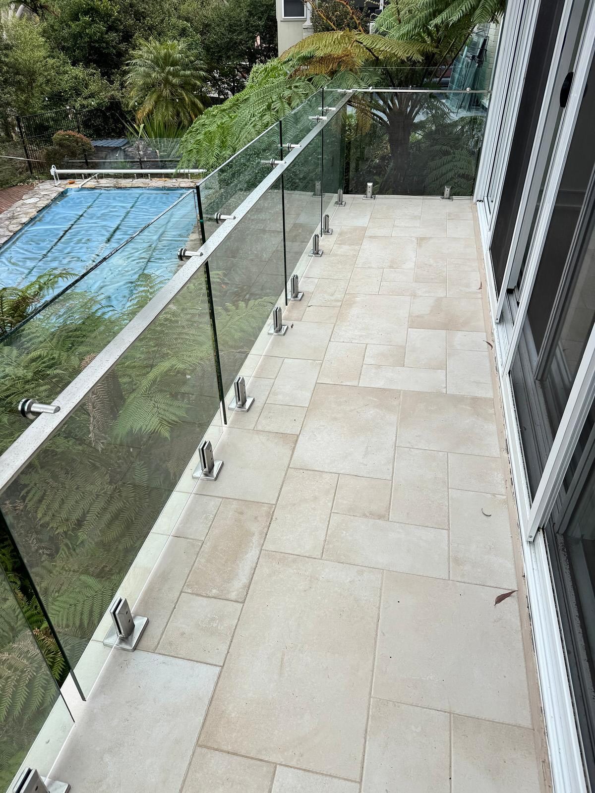 Completed tiled balcony with new glass balustrade.
