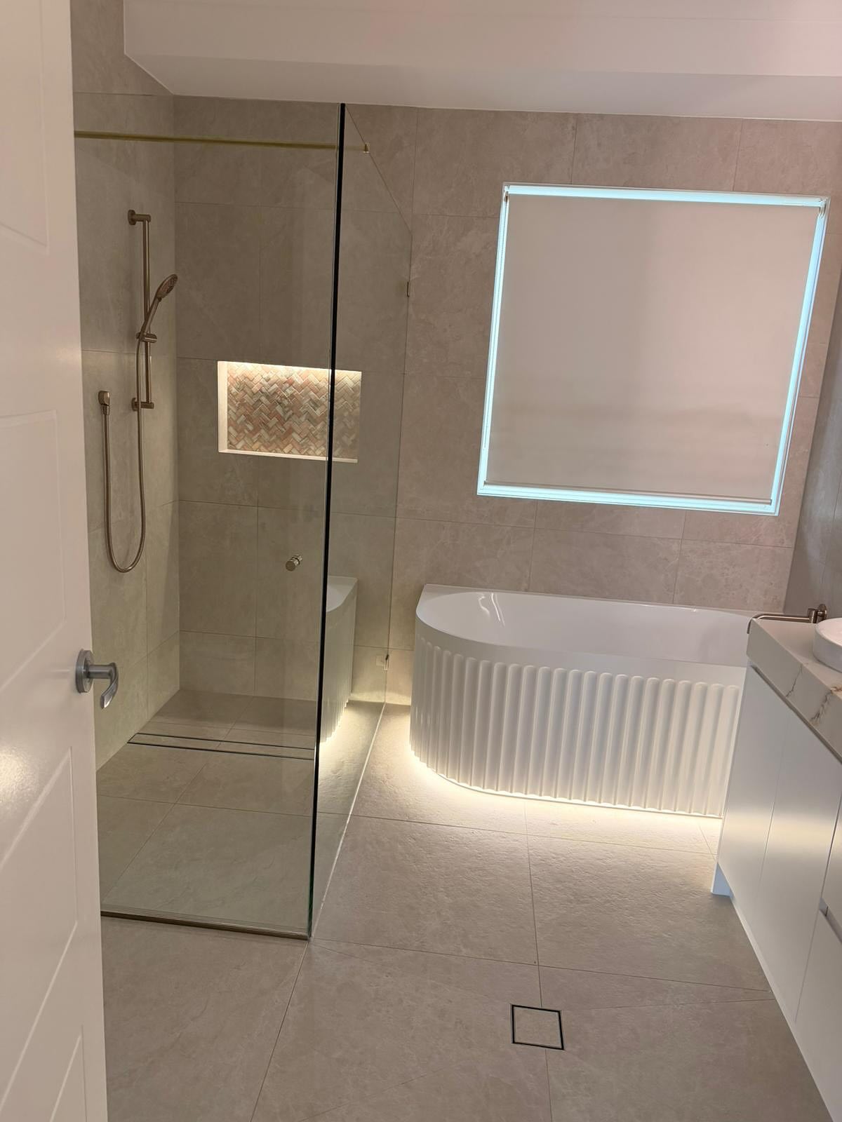 Main bathroom with freestanding bath and frameless shower.