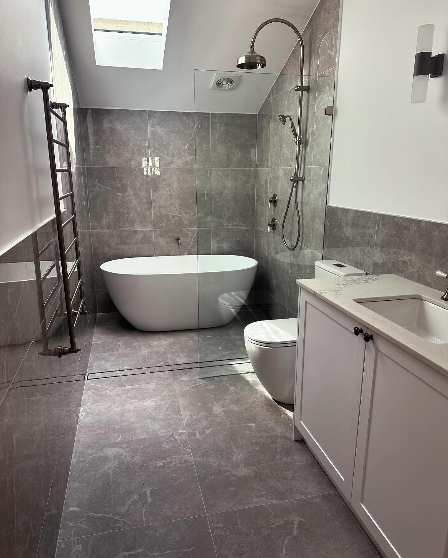 Freestanding bath, walk-in shower and overhead skylight.