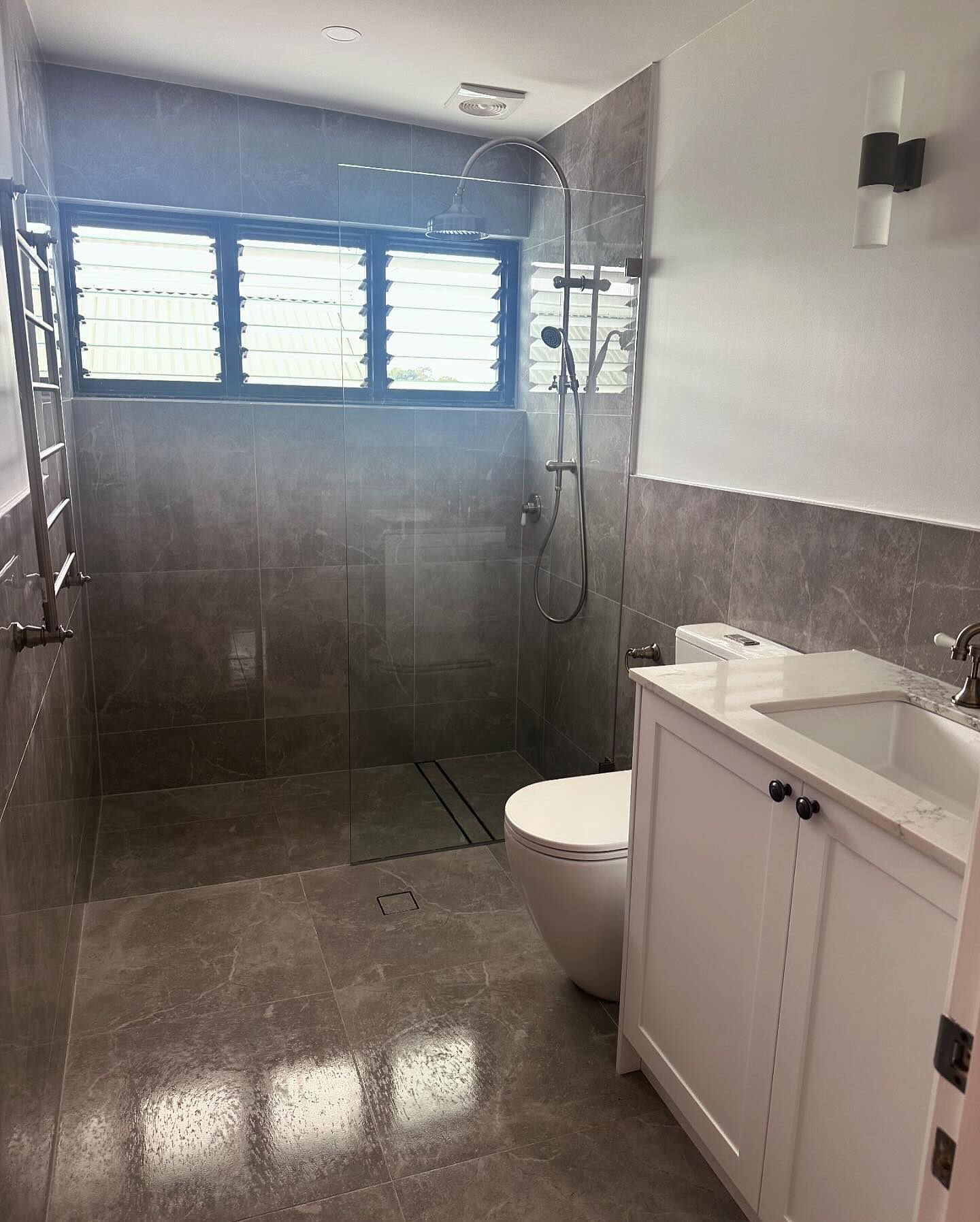 A second bathroom finished with a generous open shower.
