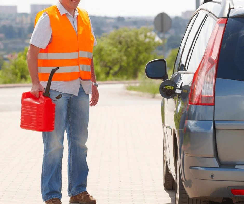 Roadside worker holding a fuel container beside a stopped car.
